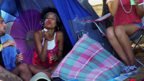 group of friends blowing bubbles at music festival 4k