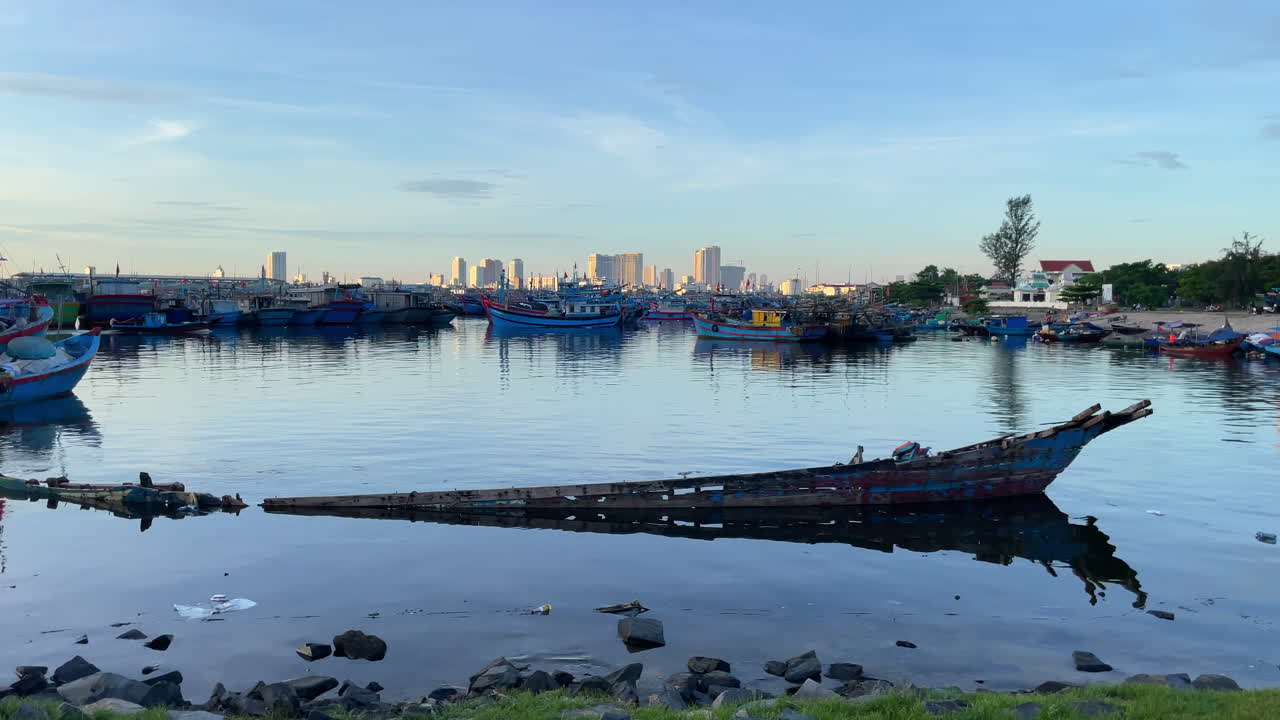 pescador miserable barco de madera tradicional en da nang con el paisaje de la ciudad en la distancia
