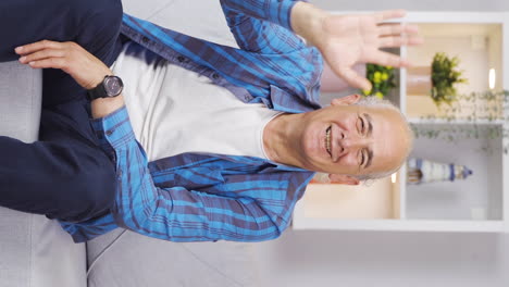 Vertical-video-of-Old-man-waving-at-the-camera.