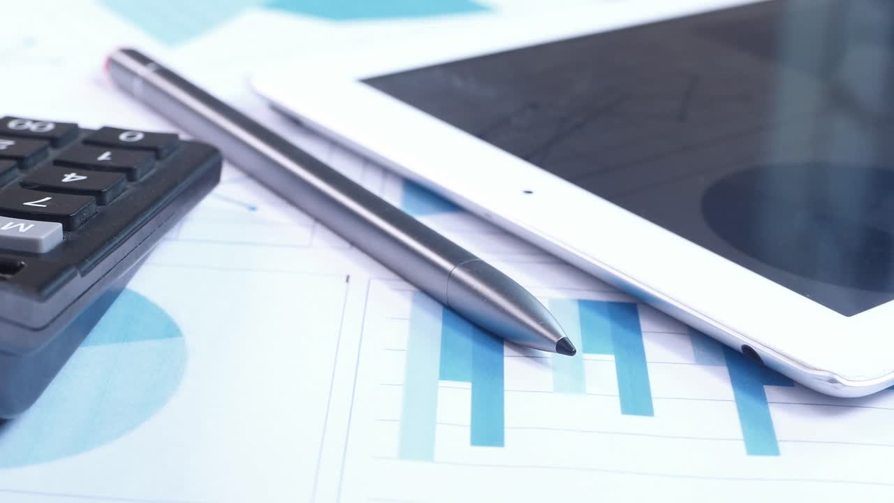 Documentos empresariales con tableta, calculadora y bolígrafo