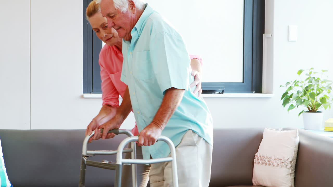 A senior woman helping a senior man standing
