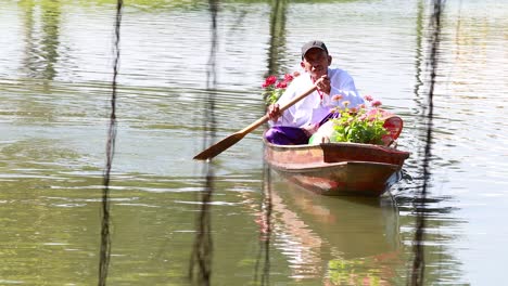 person rowing a boat with flowers