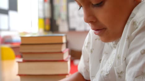 side view of attentive asian schoolboy studying with laptop in a classroom at school 4k