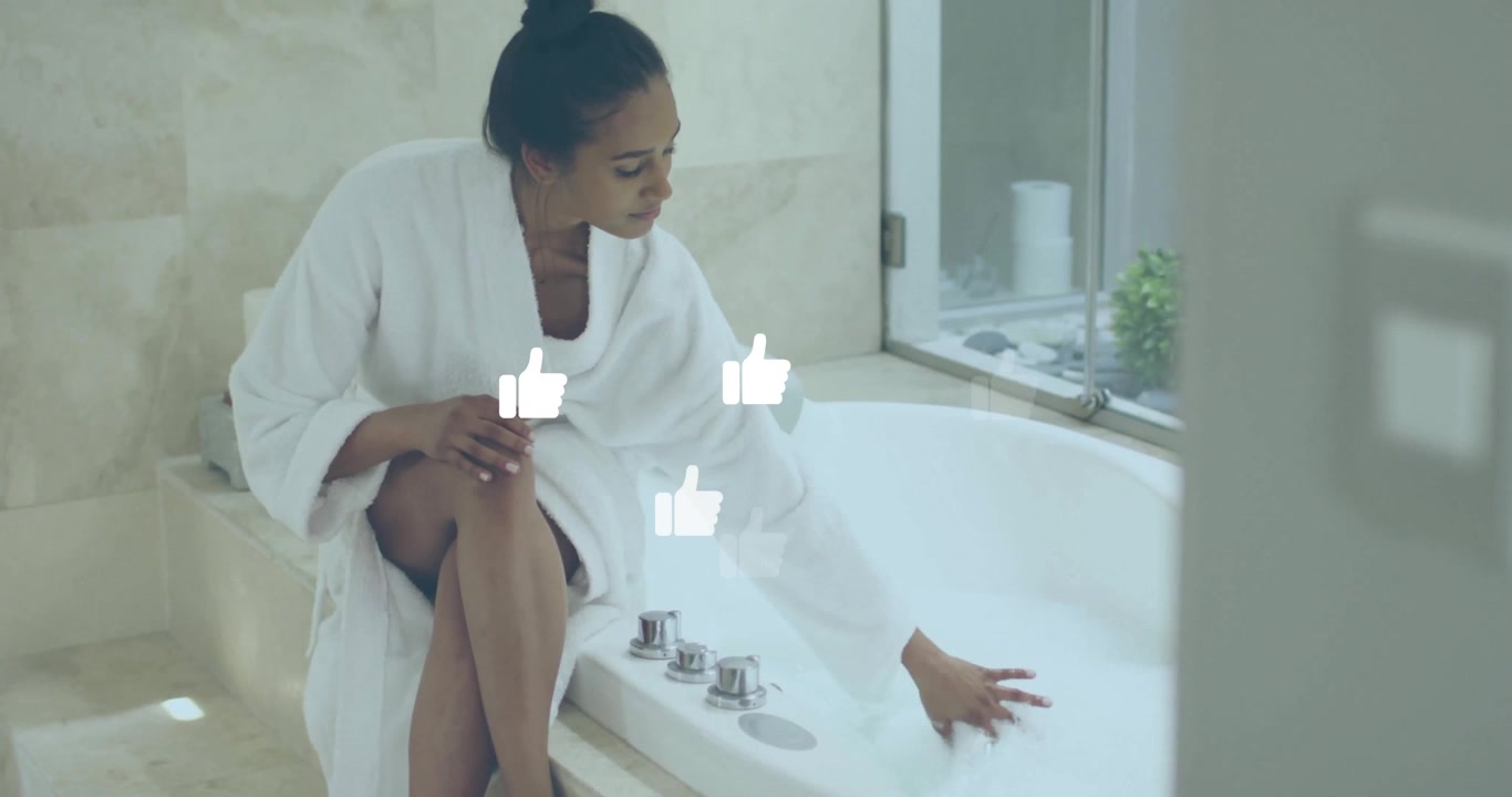 Woman in Bathrobe Testing Water Temperature in Luxury Bathtub
