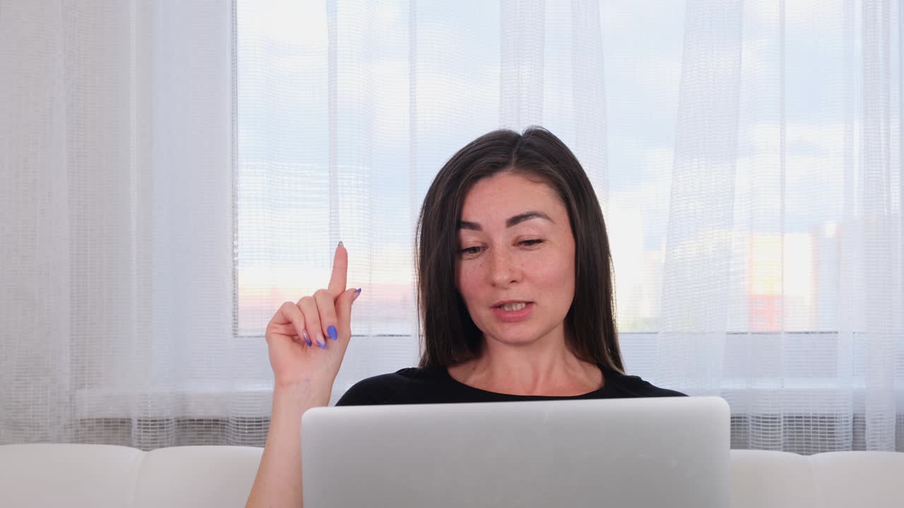 blogger mujer riendo mientras conversa con amigos en las redes sociales en la computadora portátil usando internet inalámbrico en el espacio de trabajo. joven positiva comprando en línea en el sitio web