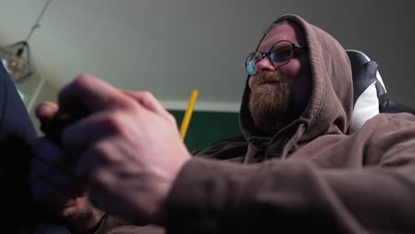 videojuegos - el hombre sacude el controlador cuando juega un juego, tiro medio de ángulo bajo