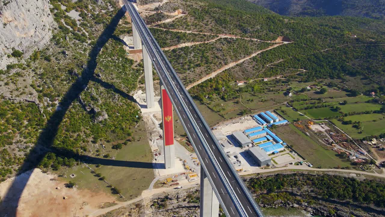 воздушный снимок полностью законченного моста морасика в черногории. большой красный герб черногории виден на одном из столбов моста