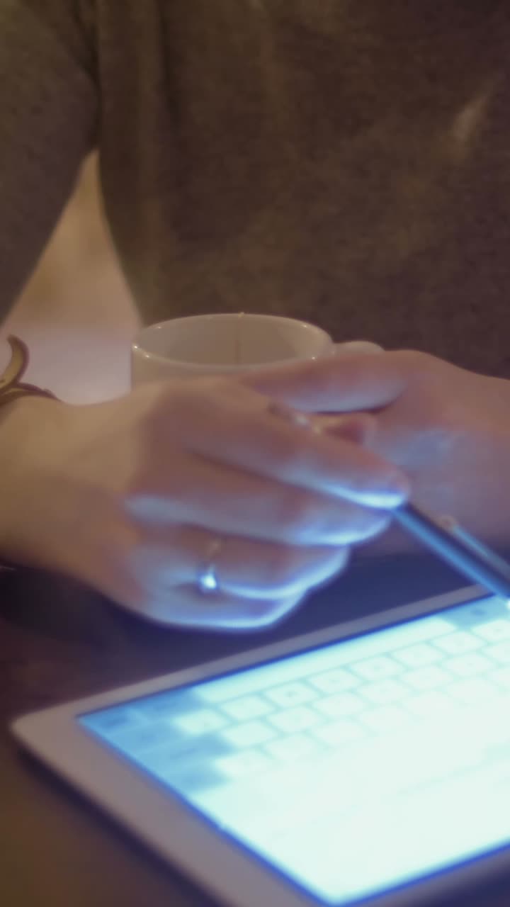 Woman using a tablet and drinking coffee