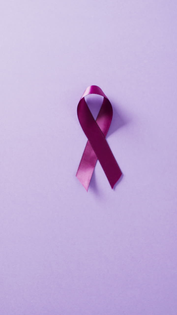 Video verticale di nastro viola per la consapevolezza del cancro al pancreas su sfondo lilla con spazio per il testo