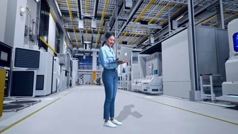 mujer trabajando en una computadora portátil en una fábrica moderna