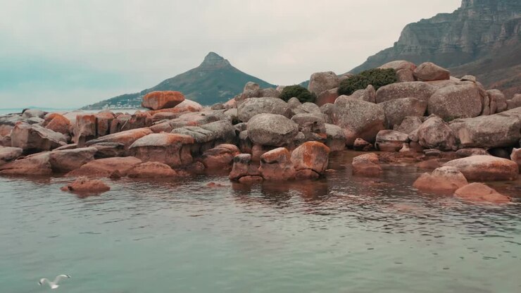 Boulders of rock lie scattered along the coastline near Cape Town, South Africa
