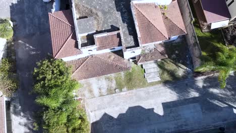 casa blanca de dos pisos abandonada con azulejos rojos