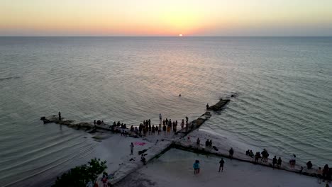 Eine-Gruppe-Von-Menschen-Genießt-Den-Sonnenuntergang-Am-Strand-Von-Holbox,-Mexiko