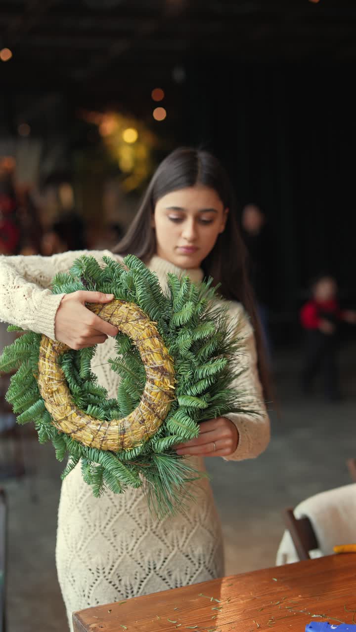 mujer haciendo una corona de Navidad