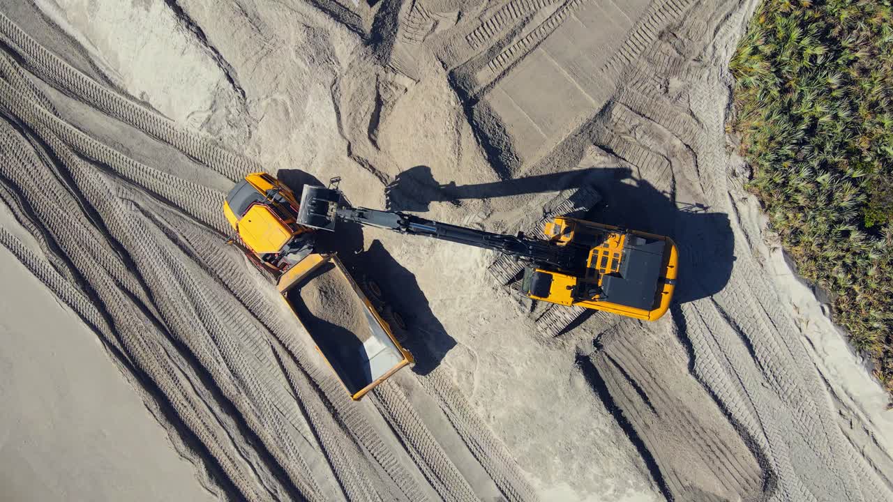 fotografía aérea de 4k de excavadoras cavando en la arena y trabajando en la playa