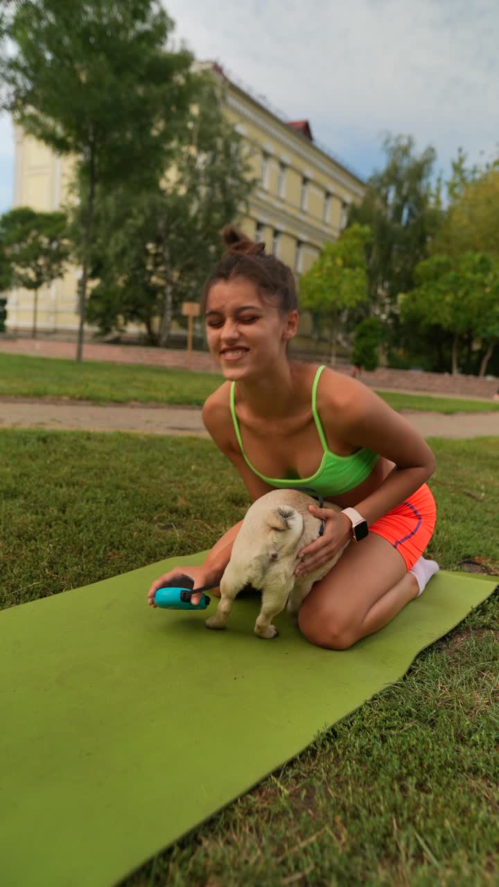 mujer practicando yoga en un parque con su perro