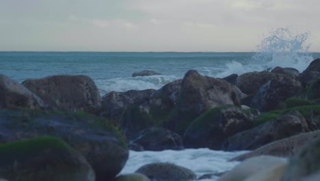 4k cinematic slow motion shot of waves hitting the rocks of a cliff during sunset, at church ope, portland, dorset.