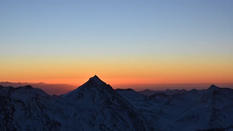 Zeitraffer-Des-Sonnenaufgangs-Auf-Dem-Gipfel-Der-Alpen,-Orangefarbener-Himmel-Und-Berg,-Der-Die-Sonne-Bedeckt