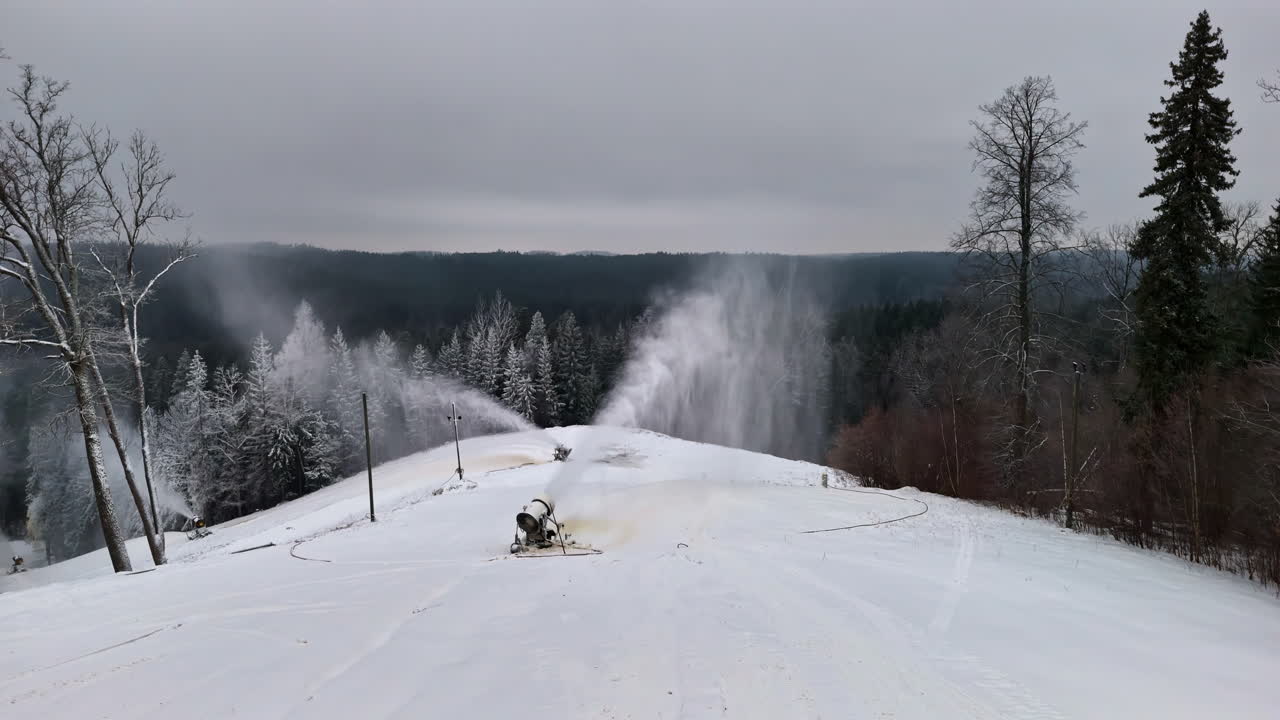 Un cannone da neve spruzza neve fine e polverosa su un paesaggio
