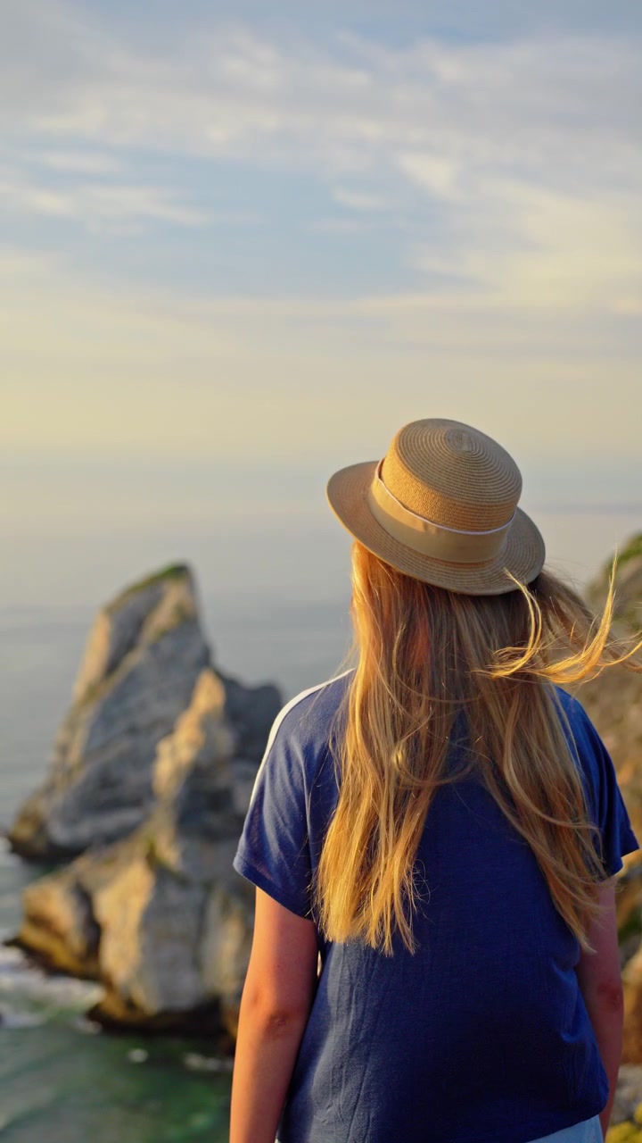 Giovane viaggiatore che ammira le scogliere costiere al tramonto