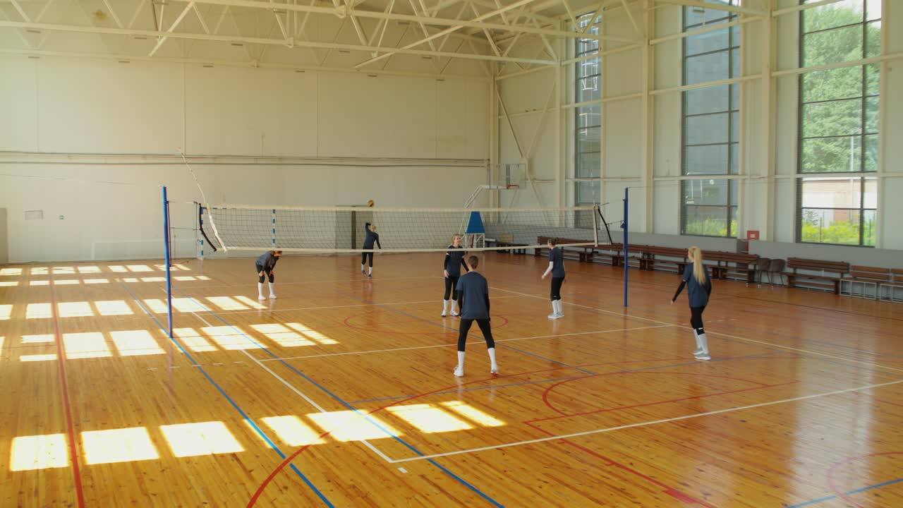 Time de vôlei jogando em local fechado