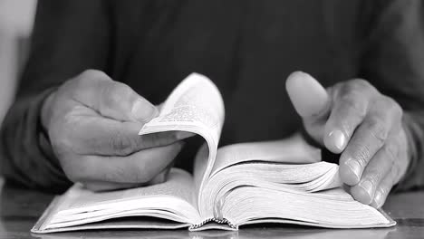 praying-to-God-with-hands-on-bible-on-table-with-people-stock-footage-stock-video