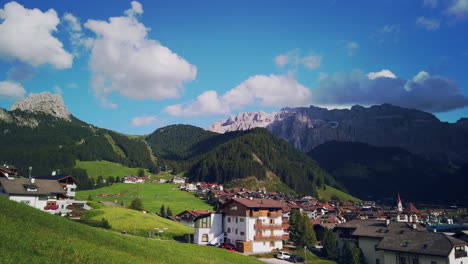 pan across selva val gardena with clouds forming over the peaks of the dolomites