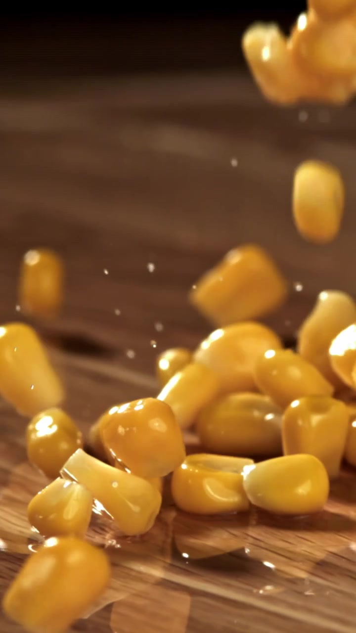 Slow Motion Fresh Corn Kernels Falling onto a Wooden Surface