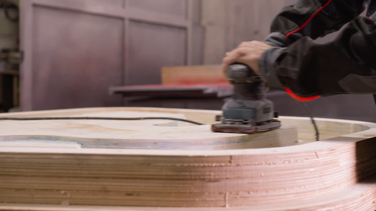 trabajador de licuado de madera contrachapada en capas en un disco grande con una licuadora eléctrica