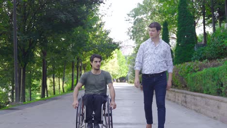 disabled teenager is driving his wheelchair and talking to his friend walking next to him.