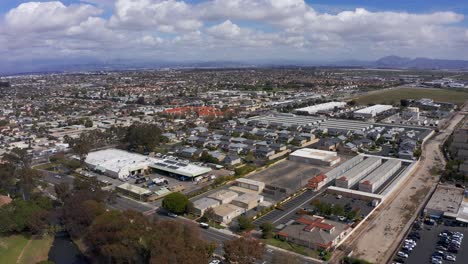 Amplia-Toma-Aérea-Inversa-De-Un-Complejo-Industrial-En-Port-Hueneme-Con-Las-Montañas-De-Santa-Mónica-Visibles-En-La-Distancia