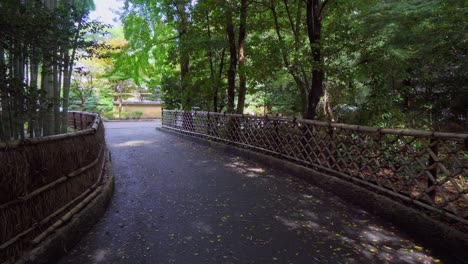 a beautiful path in a buddhist temple in japan, with a large bamboo forest on the side of the path