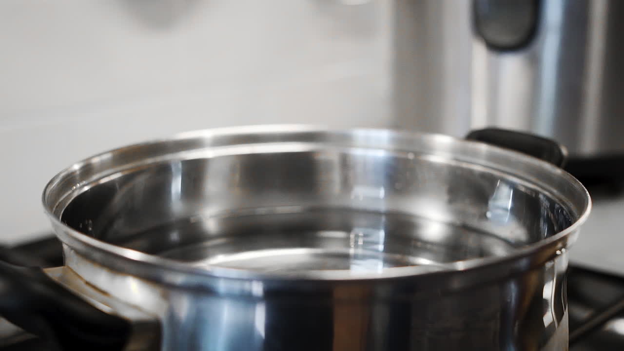 느린 동작으로 끓는 냄비의 뚜껑을 따기