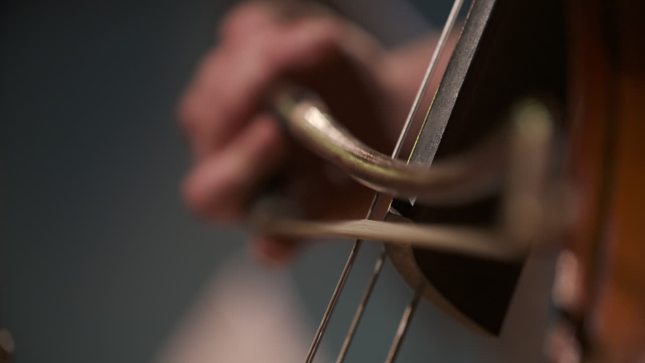 Primo piano di un musicista che suona uno strumento a corda con un archetto