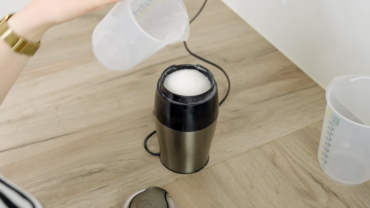 Filling regular sugar into an electric machine to make powdered sugar for tiramisu preparation