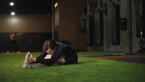 Active-fitness-man-doing-stretching-in-sport-club.-Sport-man-exercising-at-gym