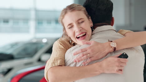 couple hugging in car dealership after purchasing new car