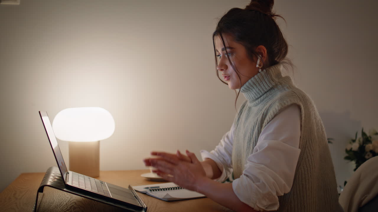 mujer comprometida hablando videocall portátil gestando por la noche en el hogar en el lugar de trabajo en primer plano