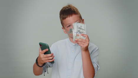 Rich-toddler-boy-with-smartphone-rejoicing-win,-receiving-money-dollar-cash,-success-lottery-luck