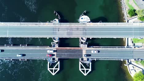 landscape pan of car traffic travelling over bridge main road town suburbs of swansea belmont newcastle australia drone aerial transport tourism