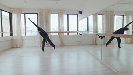 male dancer performing expressive contemporary dance on rehearsal