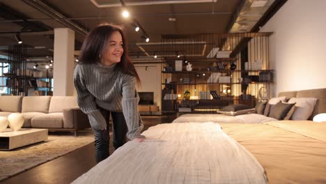 attractive positive woman chooses soft furniture for new house touching sofa attractive positive woman chooses soft furniture for new house touching sofa a large selection of comfortable furniture in a modern furniture supermarket furniture for the rest room