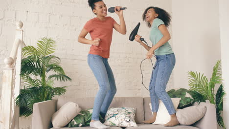 sisters singing and dancing with hair dryers and microphones