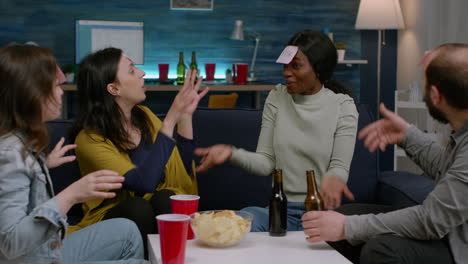 multiracial friends laughing while playing together board game using sticky notes