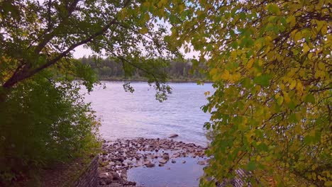 Breathtaking-view-of-the-beautiful-greensand-yellow-trees-surrounding-a-lake-in-Norway