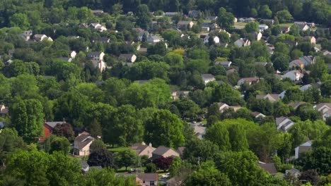 a drone aerial of homes hidden amongst trees in american town