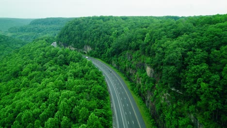 mixed convoy of semi-trucks and box trucks hauling freight along i-24 through monteagle’s scenic forested mountain pass.