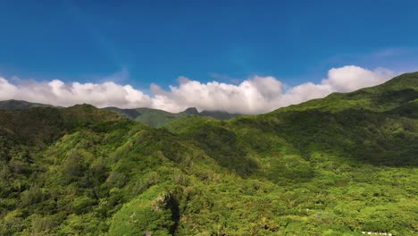 aerial approaching shot of green island with overgrown mountain and blue sky - orchid island in taiwan