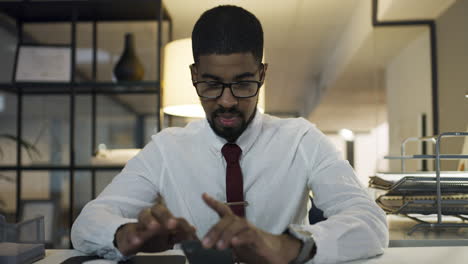 young-businessman-using-a-smartphone-during-a-late