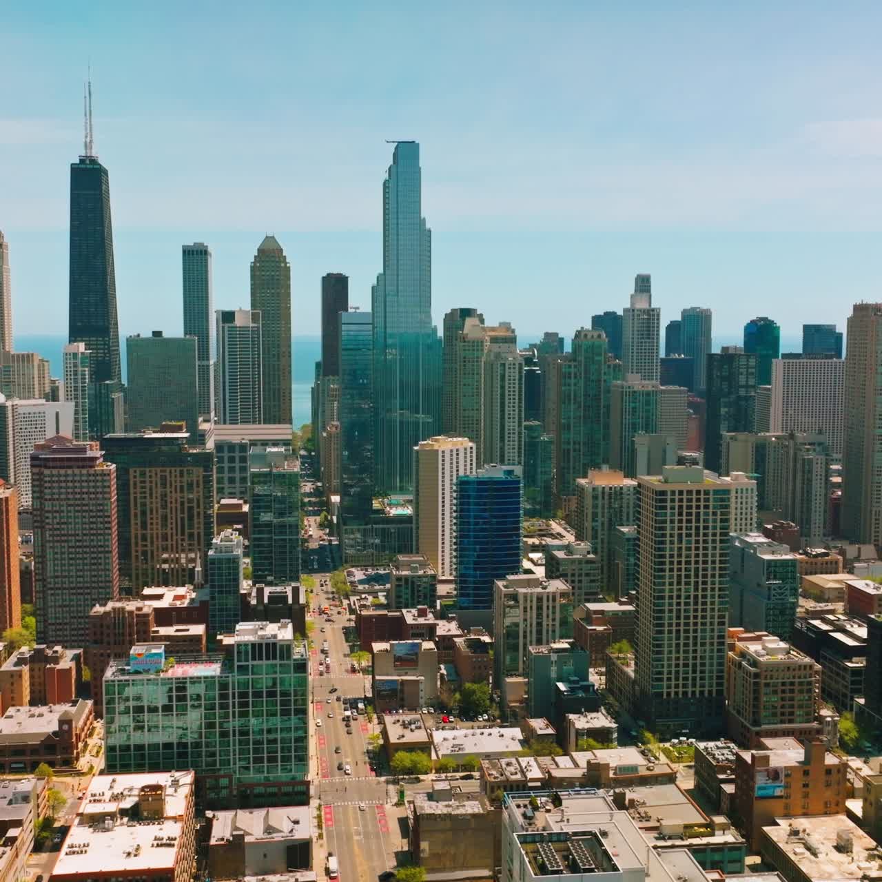 Densely built quarters of Chicago city. Vibrant and diverse architecture of modern metropolis. Blue sky and lake backdrop